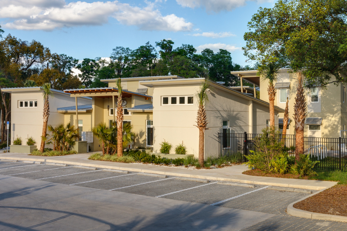 Image of eco-friendly modern designed apartment complex with sloped roofs and palm tree landscaping