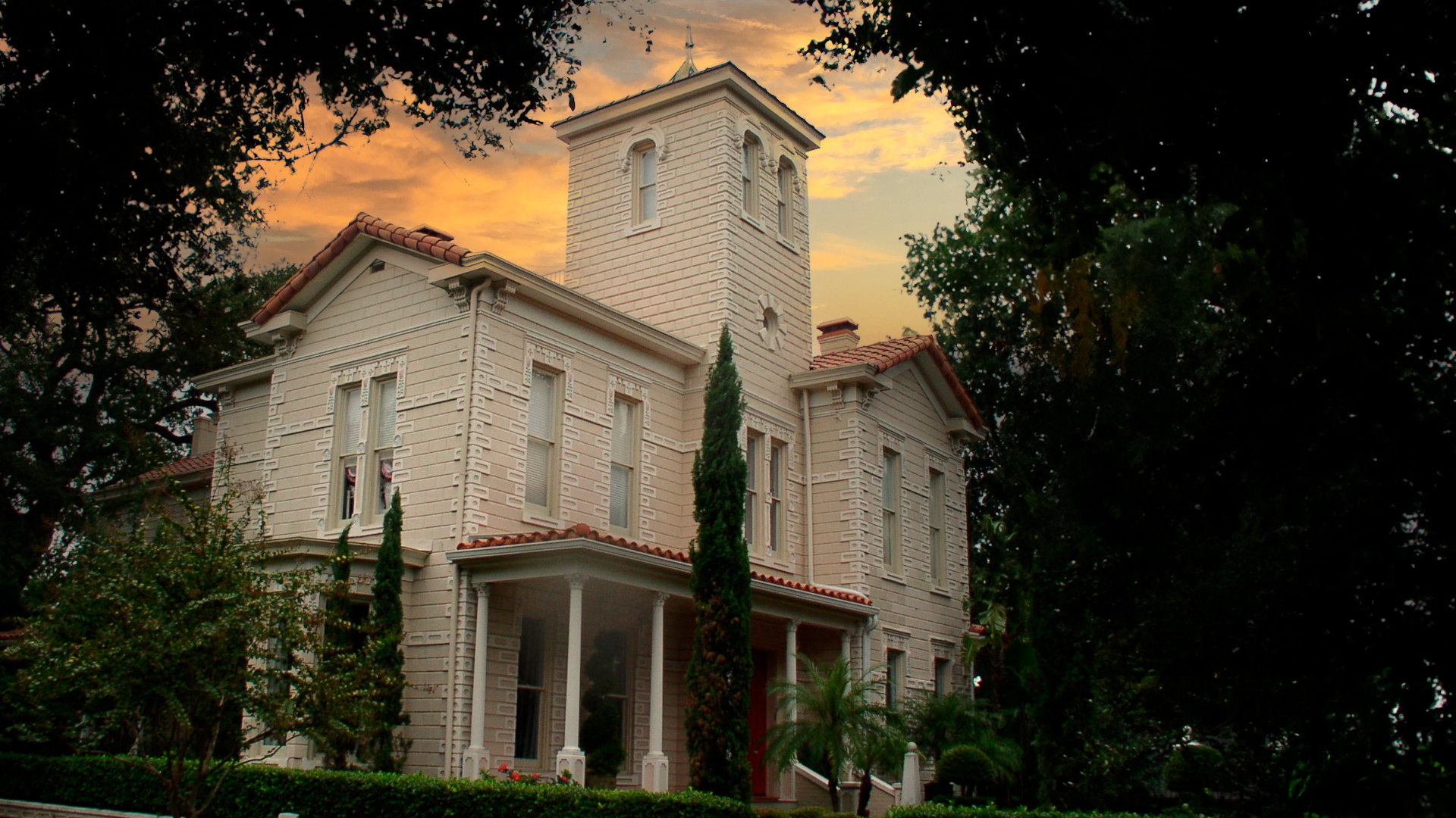 Image of historical three story home with highly ornate brickwork and red tile roof