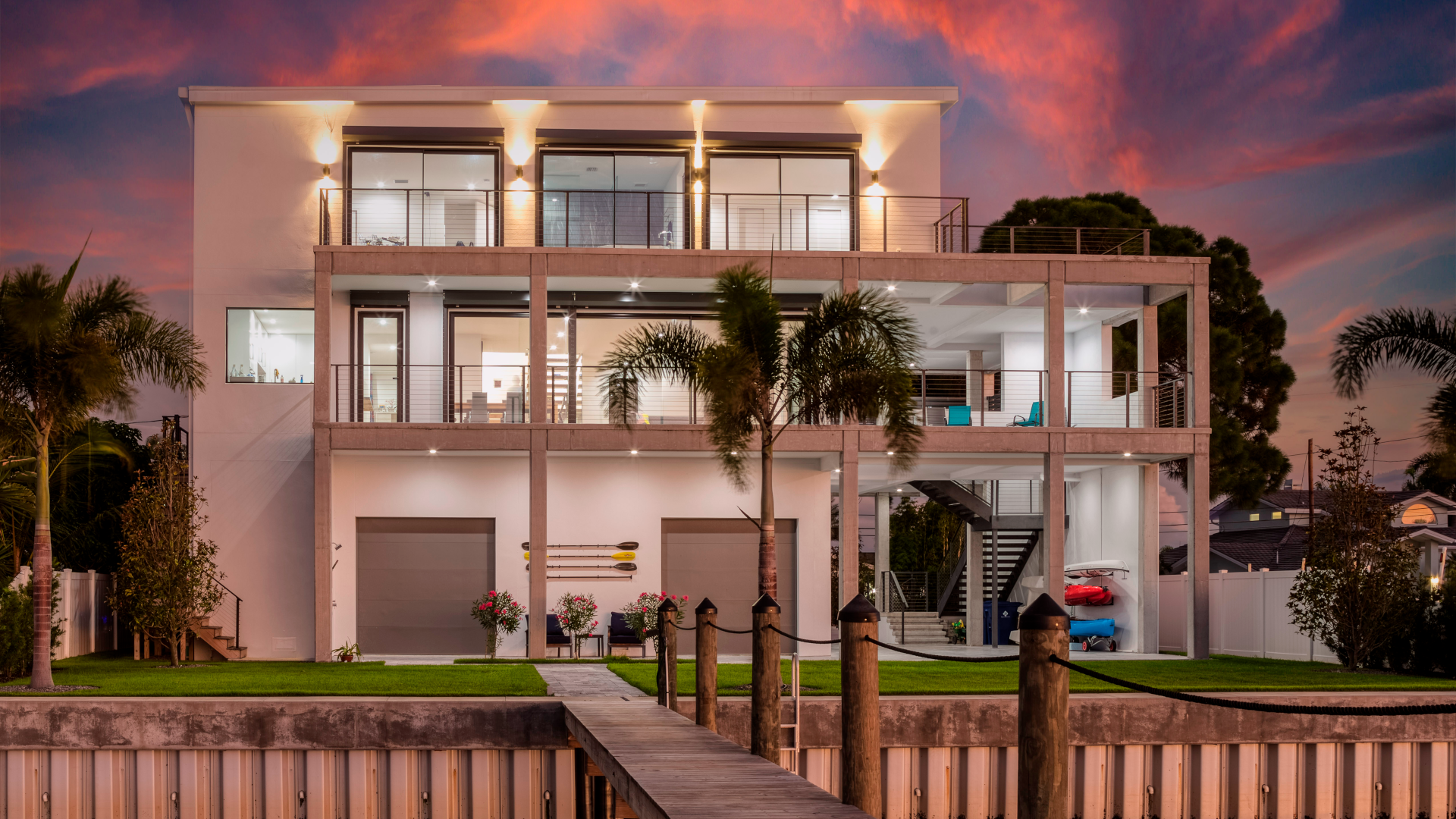 Image of modern white three story home at sunset with orange light tones