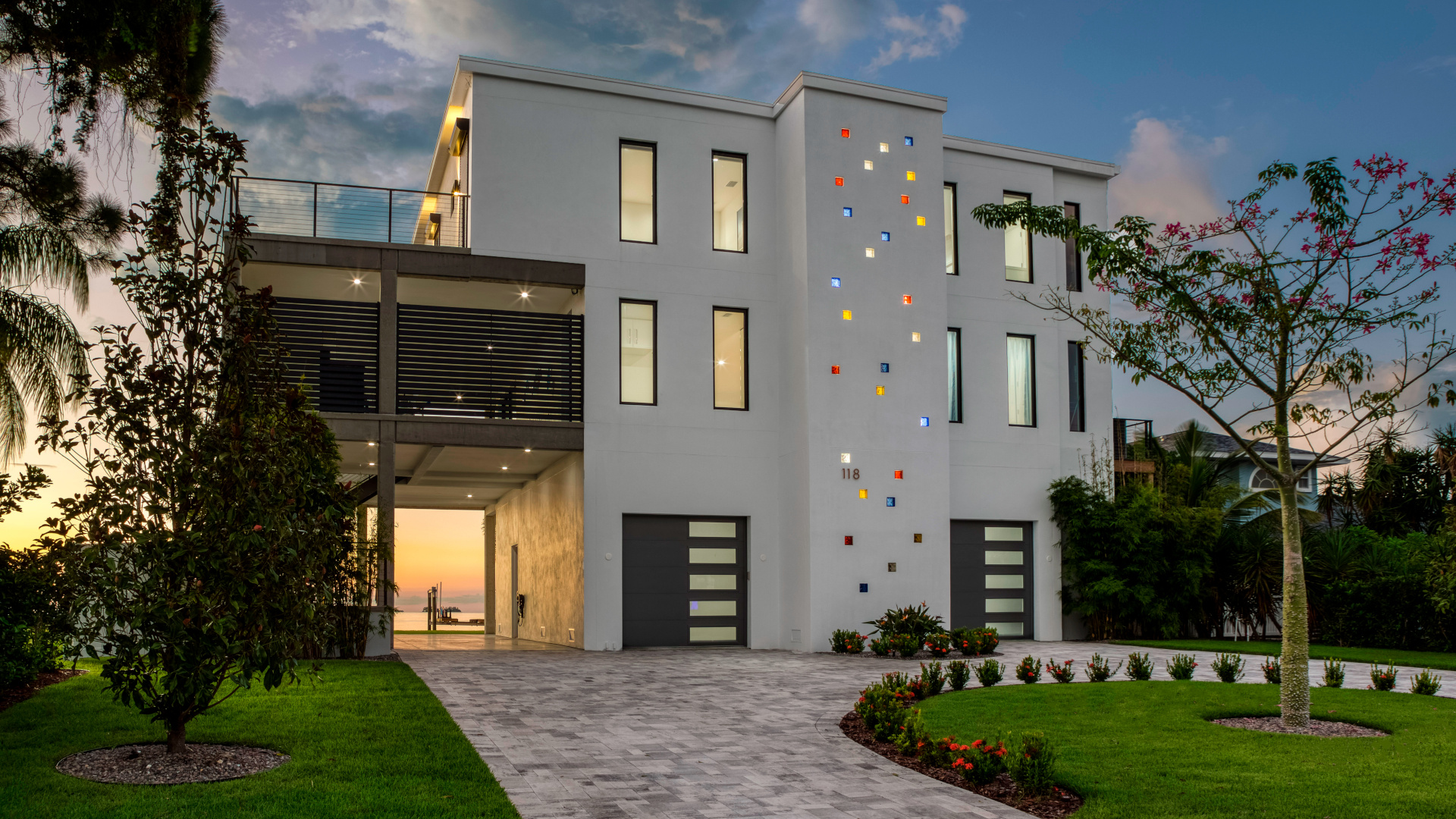 Image of modern white three storey home with black trim and custom colored glass block sprinkled up the three storey stairwell