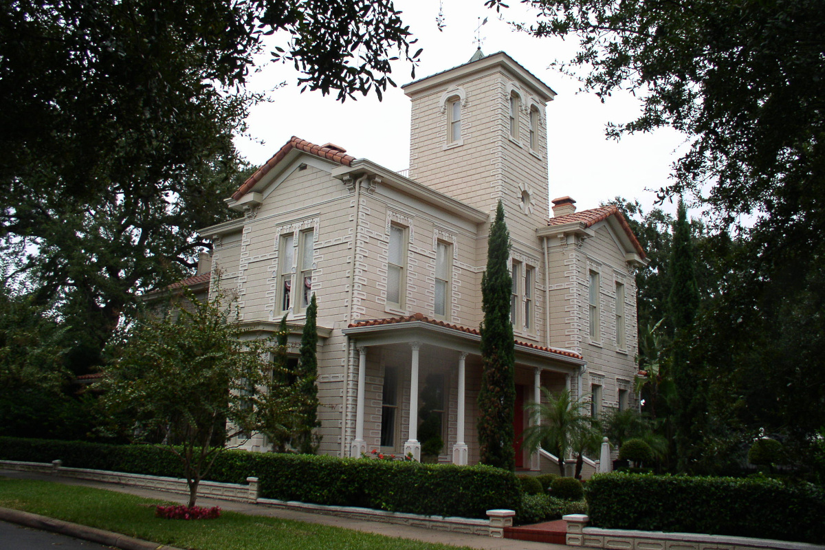 Image of historical three story home with highly ornate brickwork and red tile roof