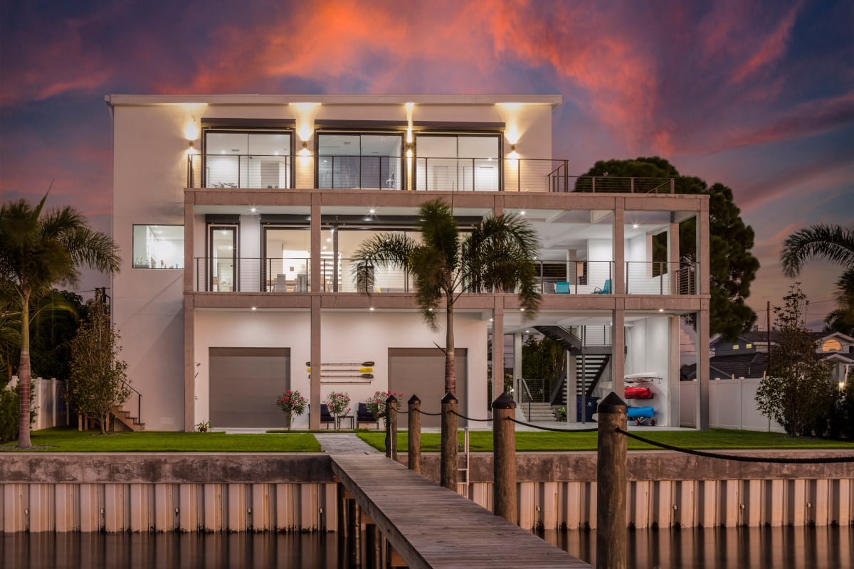 Image of back of modern white three storey home with stacked two story verandas