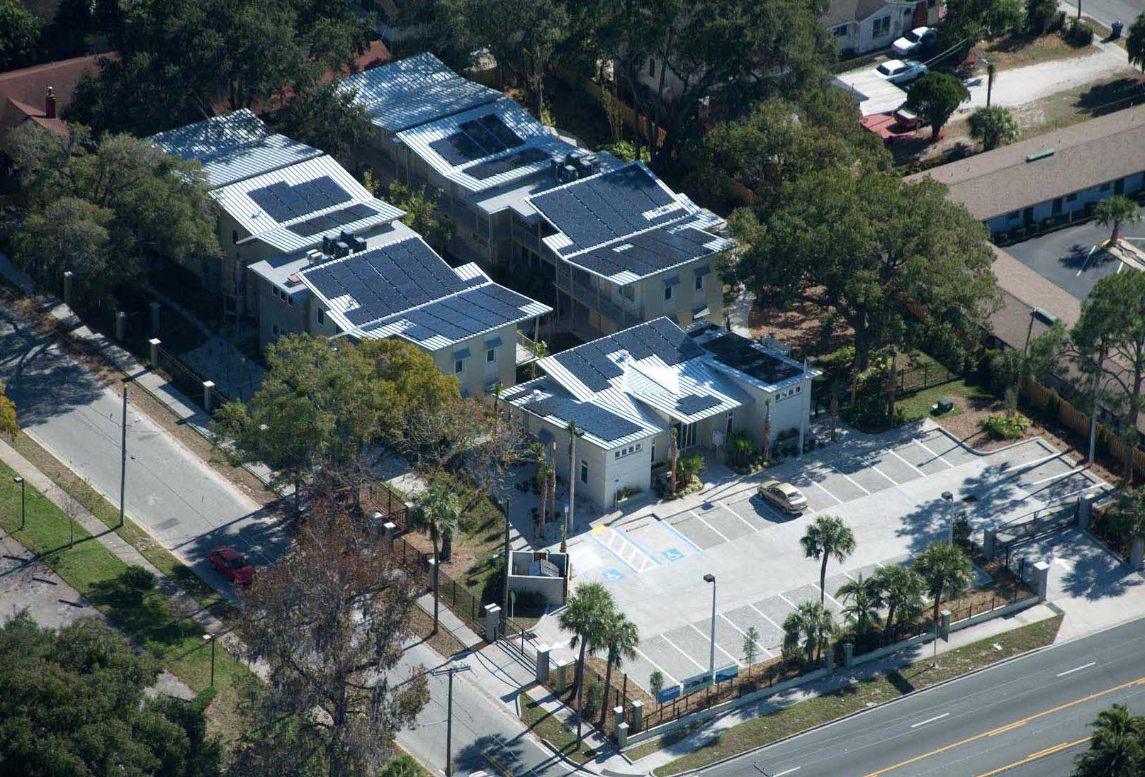 Image of arial view of eco friendly designed apartment complex with many solar arrays on the roofs